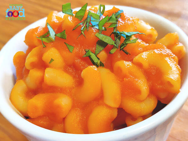 A bowl of pasta tossed in baby's carrot pasta sauce